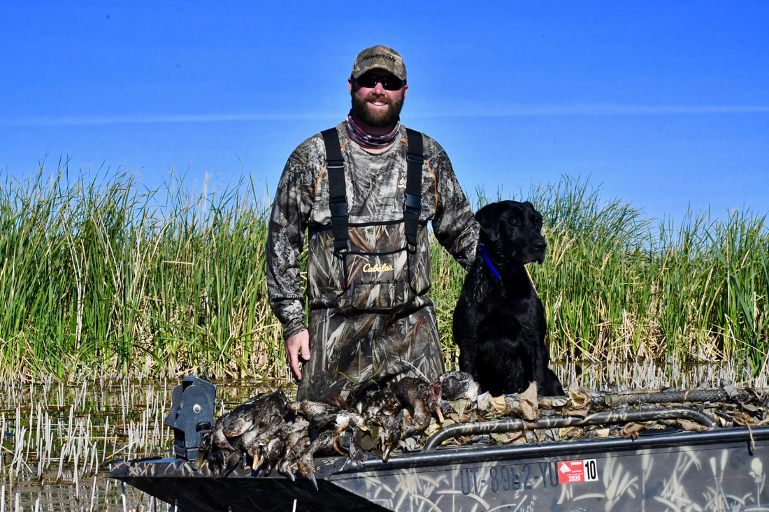 Ian Norton with a black lab after a waterfowl hunt