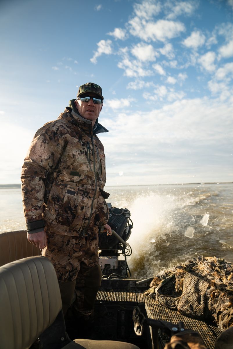 Tyce Erickson running the boat in hunting gear